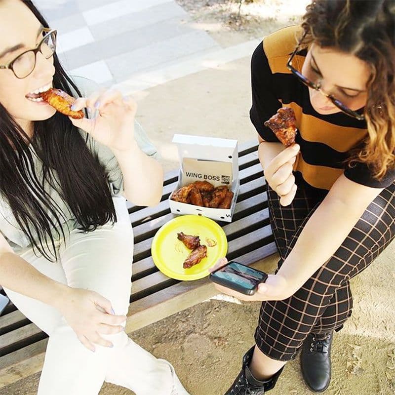 two girls eating chicken wings